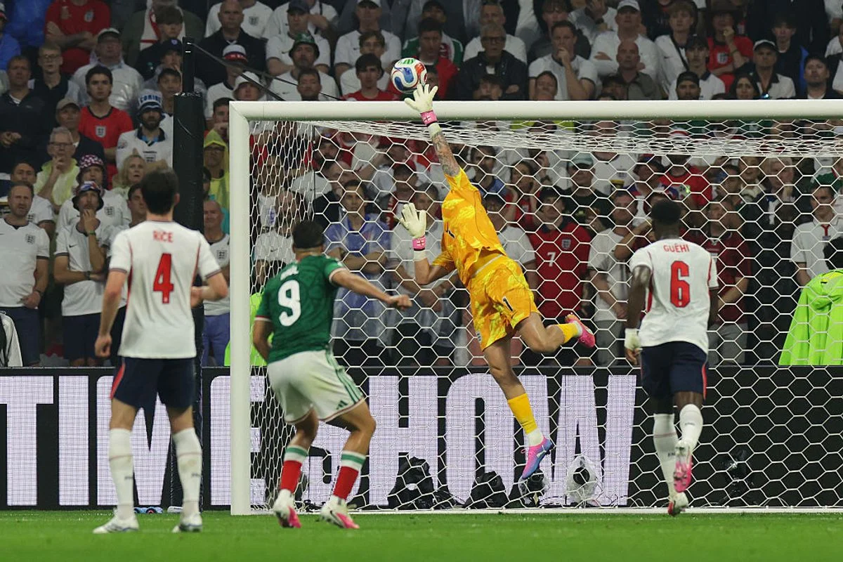 MEXICO CITY, MEXICO - JULY 05: Jordan Pickford #1 of England makes a save from Raul Jimenez #9 of Mexico during the FIFA World Cup 2026 Round of 16 match between Mexico and England at Mexico City Stadium on July 05, 2026 in Mexico City, Mexico. (Photo by Eddie Keogh - The FA/The FA via Getty Images)